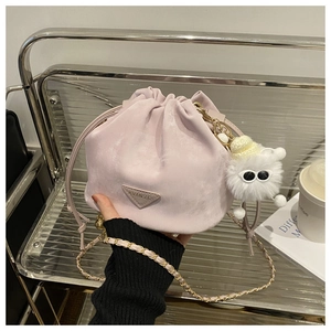 Détail du sac seau en daim violet clair avec chaîne dorée et breloque en peluche
