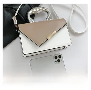 Detail showing color-block leather bag with taupe triangular flap and silver metal handle
