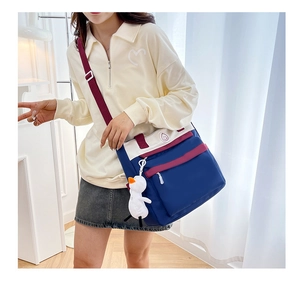 Detail of multi-color campus backpack featuring a cute duck pendant and smile badge