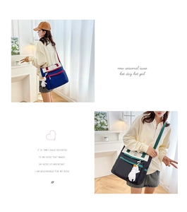 Detail of canvas messenger bag with contrast straps and a cute white duck pendant