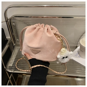 Détail d'un sac seau rose avec bandoulière en chaîne dorée et charm peluche blanc