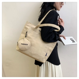 Detail of canvas tote bag with fashion lettering and circular coin purse accessory