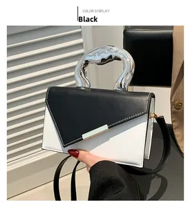 Close-up of black and white leather handbag featuring an irregular silver metal handle
