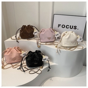 Détail de cinq mini sacs seaux colorés avec des charms moutons en peluche et bandoulières