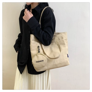 Detail of beige canvas tote bag with fashion coin purse and wide shoulder strap