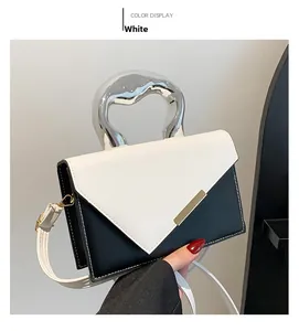 Detail of color-block crossbody bag with unique liquid metal handle and white leather texture