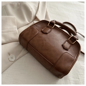 Detail of vintage brown leather handbag with ORNI ORNI logo and bronze hardware