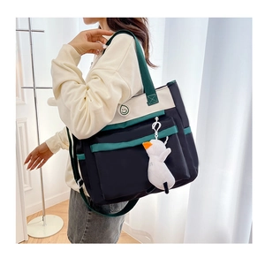 Detail of multi-color student tote bag with smiley logo and plush duck pendant
