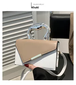 Detail of khaki leather handbag with artistic silver molten metal handle design