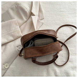 Top view of brown retro handbag showing internal capacity with a wallet and cards