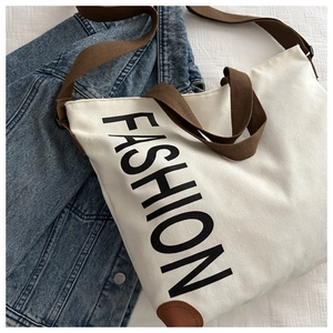 Gros plan du sac cabas en toile avec imprimé FASHION et renforts d'angle en cuir