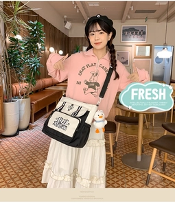 Detail of black and white canvas crossbody bag with cute white duck plush keychain