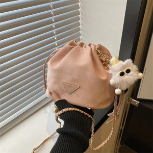 Mini sac seau rose avec texture ondulée, bandoulière chaîne dorée et charm peluche