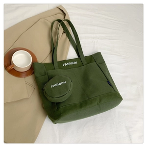 Detailed view of deep green canvas tote bag with fashion print and mini pouch