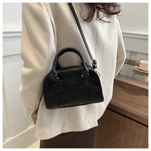 Close-up of black retro Boston bag with ORIN logo engraving and golden hardware