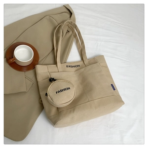 Detail of minimalist beige canvas tote bag with round coin purse and fashion print