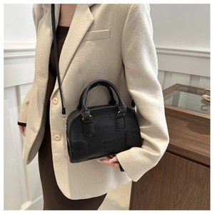 Detail of black Boston handbag with embossed logo and textured synthetic leather