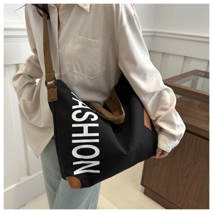 Détail d'un grand cabas en toile noire avec imprimé FASHION et accents en cuir