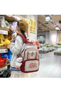 Close-up of red and white school backpack with cute duck plush charm and large capacity