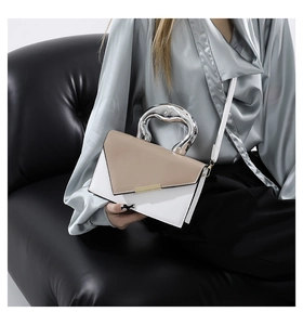 Detailed view of fashion leather handbag featuring a unique silver liquid metal handle