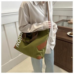 Détail du sac cabas en toile vert avocat avec anses brunes et lettrage FASHION