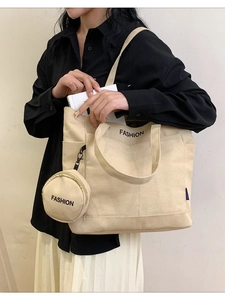 Minimalist canvas tote bag with fashion print and round purse on shoulder of female model