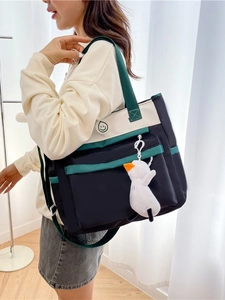 Three-way canvas tutor tote bag with green trim, shoulder strap and plush duck charm