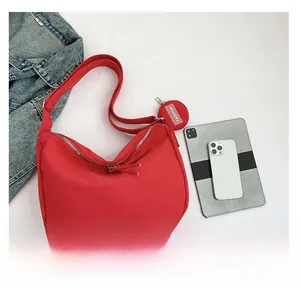 Détail du sac hobo rouge en nylon avec fermeture éclair argentée et petit porte-monnaie