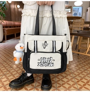 Detail view of canvas tote bag with contrast piping and cute plush duck pendant