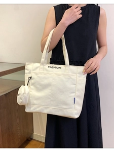 Minimalist white canvas tote bag with a small coin purse and bold FASHION print