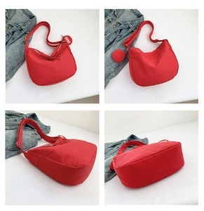 Vue détaillée du sac bandoulière rouge en nylon avec sangle large et mini porte-monnaie