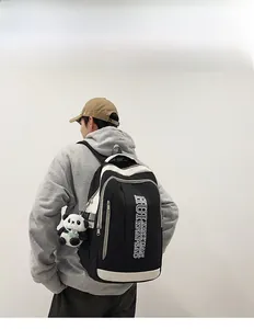Detail of high-capacity contrast nylon backpack with panda charm on model