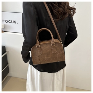 Detail of a brown vintage doctor bag with ORN ORN letter embossing and sturdy top handle