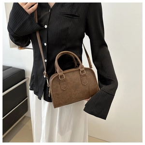 Detail view of retro brown Boston bag with embossed ORN logo and dual zipper closure