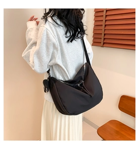 Détail du sac bandoulière en nylon noir avec une petite pochette amovible assortie