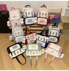 Group shot of colorful canvas backpacks and tote bags with cute white duck pendants