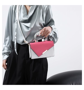 Detail of pink and white crossbody bag with silver handle and sleek metal buckle