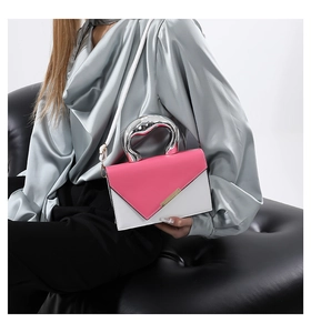 Close-up of modern two-tone crossbody bag with silver liquid metal ring handle