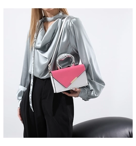 Detail of color-block envelope handbag with a unique silver liquid metal handle design