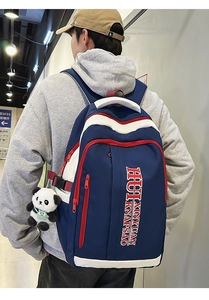 Detail of navy blue contrast backpack with panda plush charm shown on person