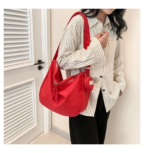 Détail du sac cabas rouge avec fermeture zippée et mini pochette ronde assortie de mode
