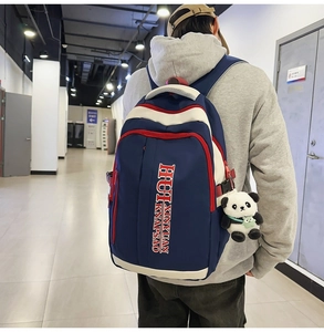 Detail view of large nylon backpack showing durable zippers and side buckles with panda charm