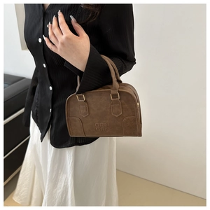 Brown vintage Boston bag with pebbled leather texture and elegant hand-carry handle