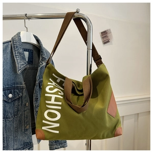 Détail du sac cabas en toile verte avec imprimé FASHION blanc et détails en cuir brun