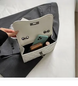 Interior view of white quilted crossbody bag showing spacious capacity for phone and wallet