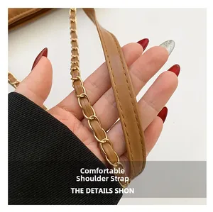 Détail des bandoulières en cuir PU marron et chaîne en métal doré sur un sac cabas matelassé