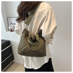 Detailansicht olivgrüne Nylon-Tasche mit verstellbarem breitem Schultergurt an einem Model