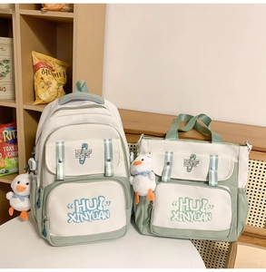 Detail view of cream and sage green school backpack set with cute duck charms