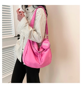 Détail du sac hobo rose vif en nylon avec un petit porte-monnaie assorti accroché