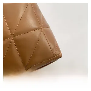 Gros plan sur le cuir matelassé marron caramel montrant les coutures et la texture en losange